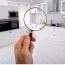 Man holding magnifying glass over the kitchen