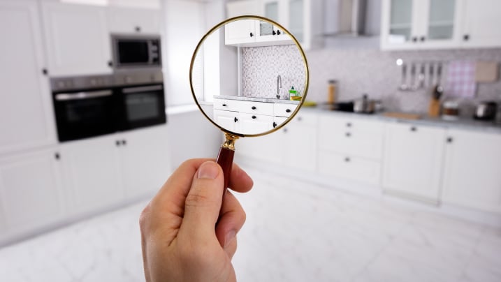 Man holding magnifying glass over the kitchen