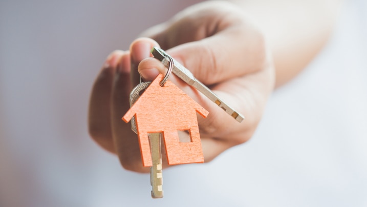 person's hand holding house key