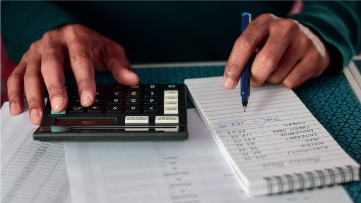 man calculating household expenses with a calculator