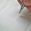 a person's hand writing a cheque