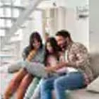 family of 3 having fun using laptop at home.