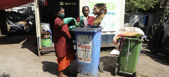 Women from Stree Mukti Sanghatana weigh dry waste collected for the day