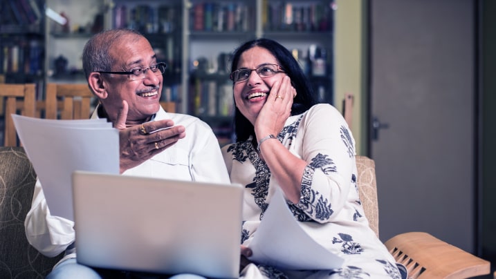 An elderly couple sitting on a couch