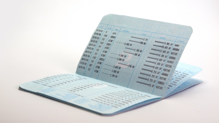 A financial advisor explaining average monthly balance calculations to a client with a graph in the background.
